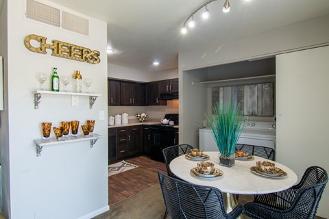Dining area with white table and black chairs at The Boulevard Apartments, Roeland Park, KS