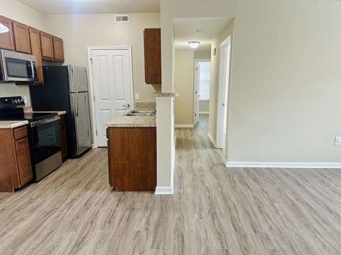 A kitchen with a refrigerator, microwave, and oven.