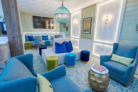 A living room with blue chairs and a white wall.