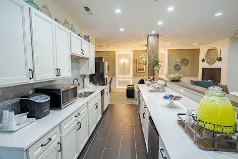 A kitchen with white cabinets and a black refrigerator.