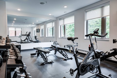 A gym with a row of treadmills and stationary bikes. at The MK, Indiana, 46220