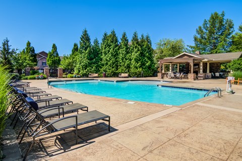 A large swimming pool surrounded by lounge chairs and trees at Sovereign at Overland Park Apartments, Overland Park, 66213