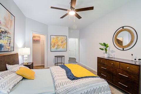 A bedroom with a bed, a ceiling fan, and a painting on the wall at Sovereign at Overland Park Apartments, Overland Park, 66213