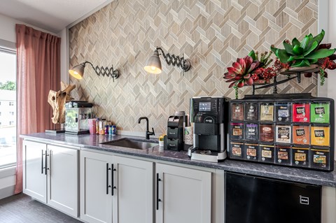 A kitchen with a black fridge and a black counter top.