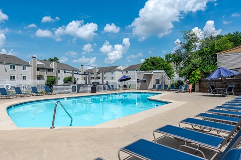 Swimming pool with lounge chairs and umbrellas at Candles Apartments, Springfield, 62704