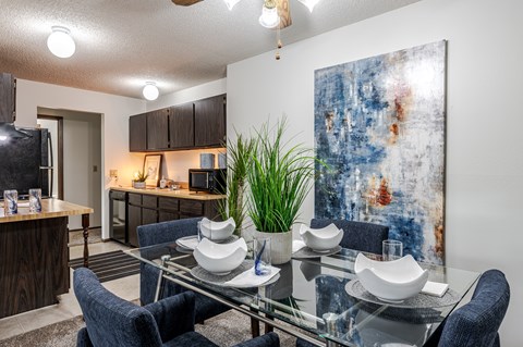 Dining area with glass table and abstract artwork at Candles Apartments, Springfield, 62704