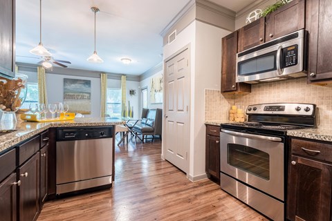 A kitchen with dark wood cabinets and stainless steel appliances.