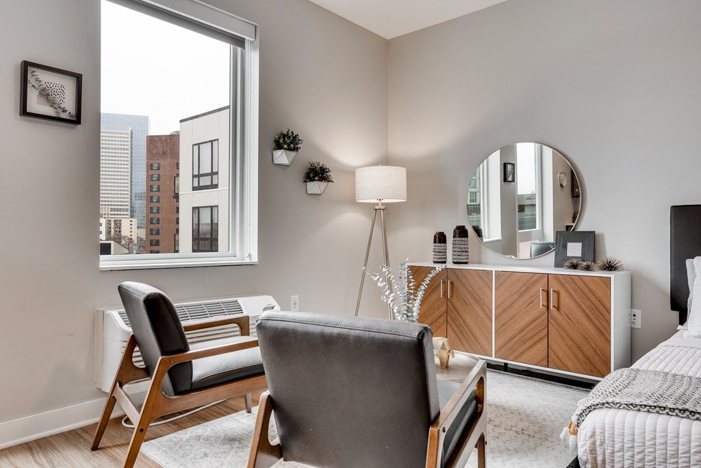 a bedroom with a large window and a chair and a desk with a mirror at Marquee, Minneapolis, Minnesota