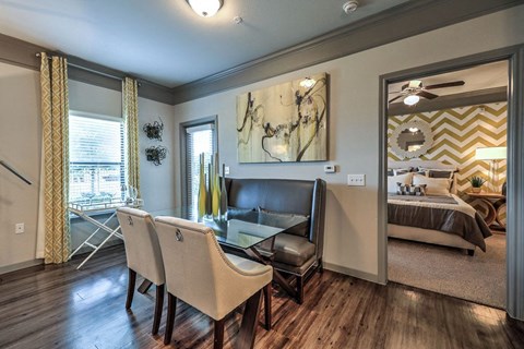 a living room with a table and chairs and a bedroom  at Waterstone at Cinco Ranch, Katy