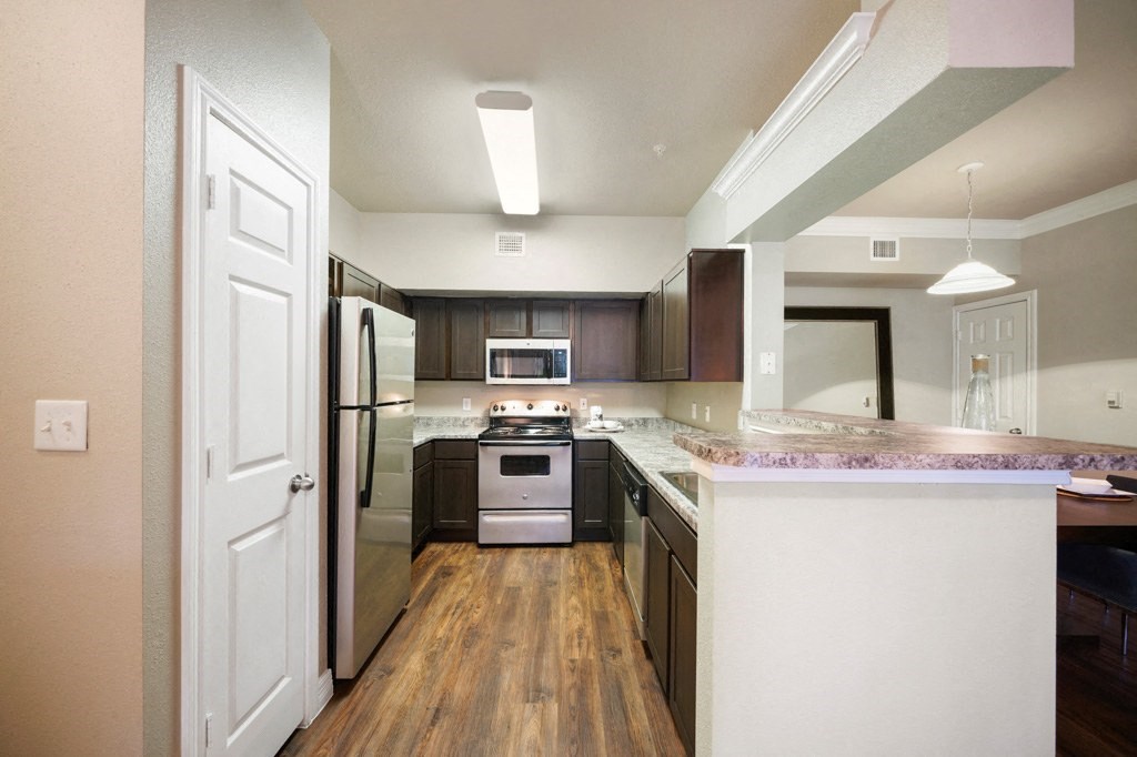 galley kitchen with stainless steel appliances at River Pointe, Conroe, TX, 77304