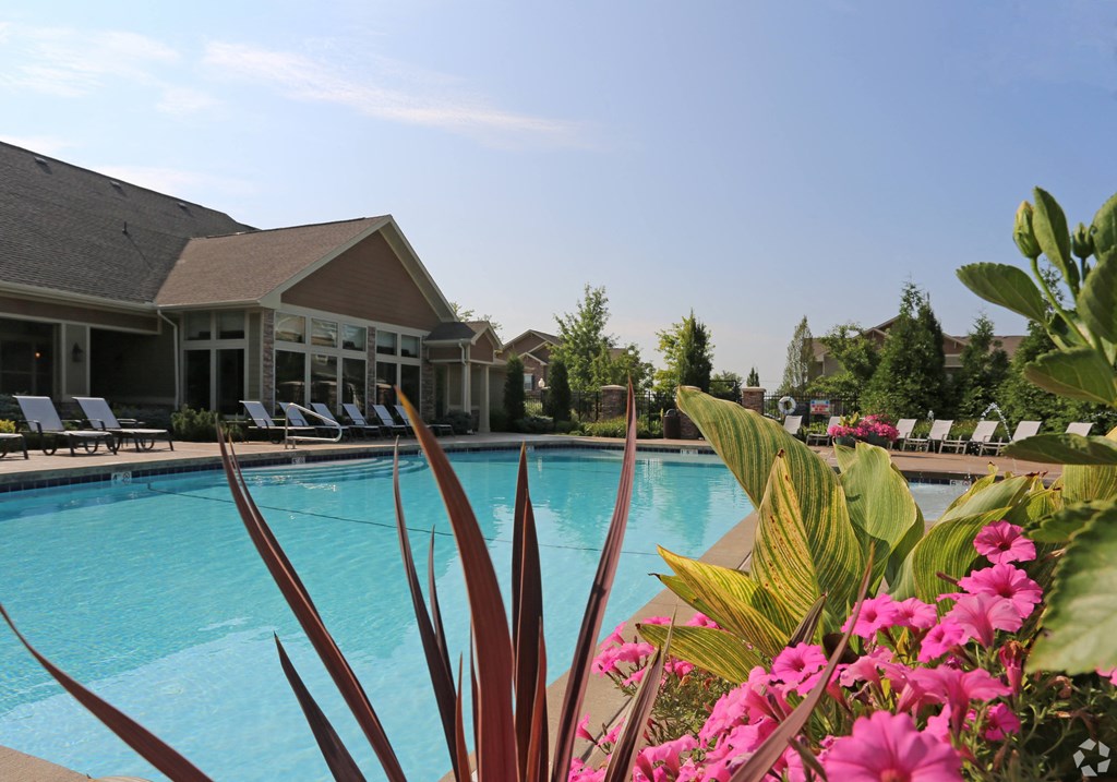 a swimming pool with pink flowers in front of a house at Sovereign at Overland Park, Overland Park, 66213