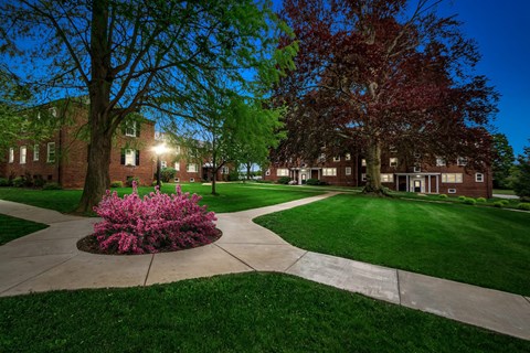 a sidewalk in front of a brick building at night