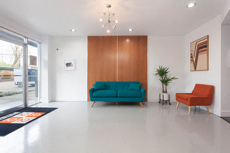 a living room with a blue couch and two orange chairs
