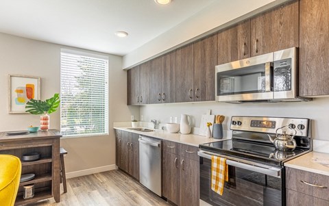 a kitchen with wooden cabinets and a stove and microwave