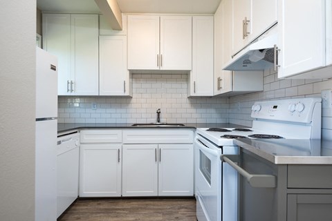 a white kitchen with white cabinets and white appliances
