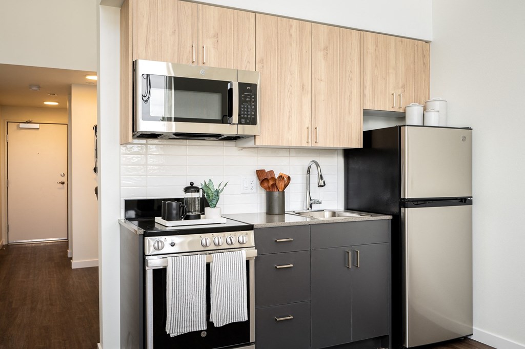 a small kitchen with stainless steel appliances and a microwave