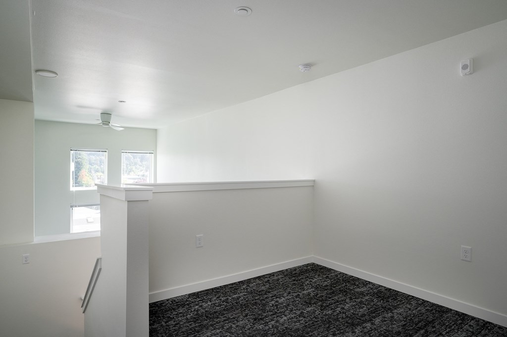 an empty living room with carpet and white walls