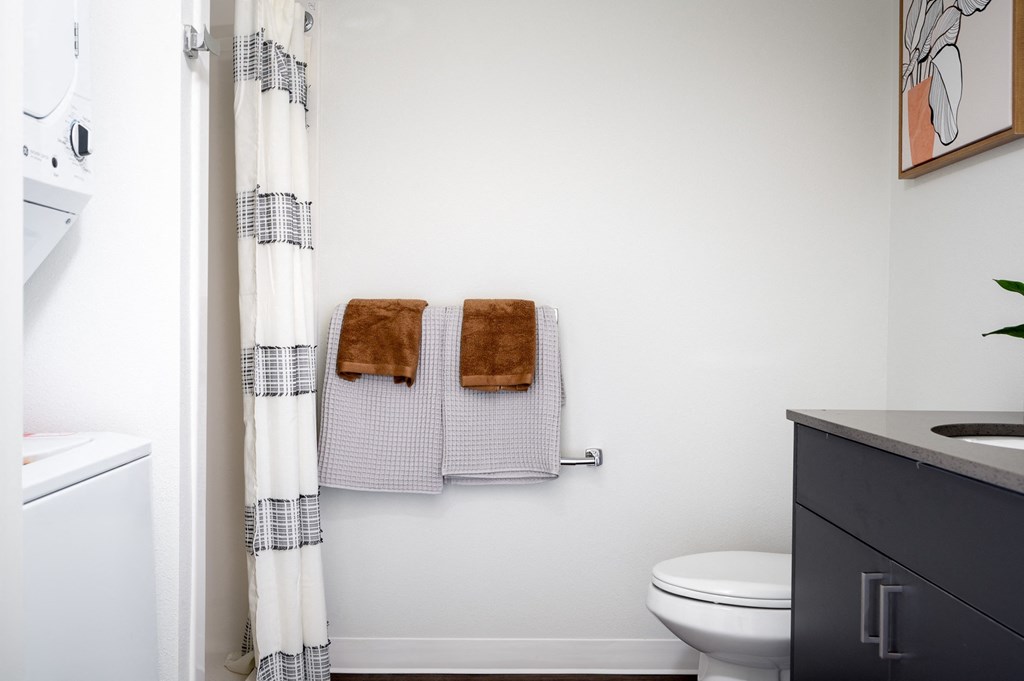 a bathroom with two towels and a toilet and a shower curtain
