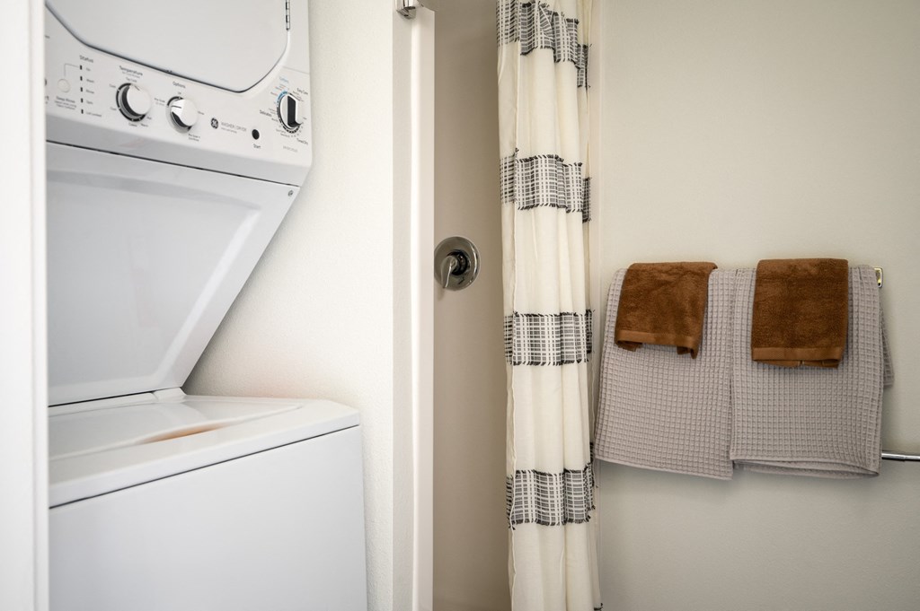 bathroom with shower and stacked washer and dryer