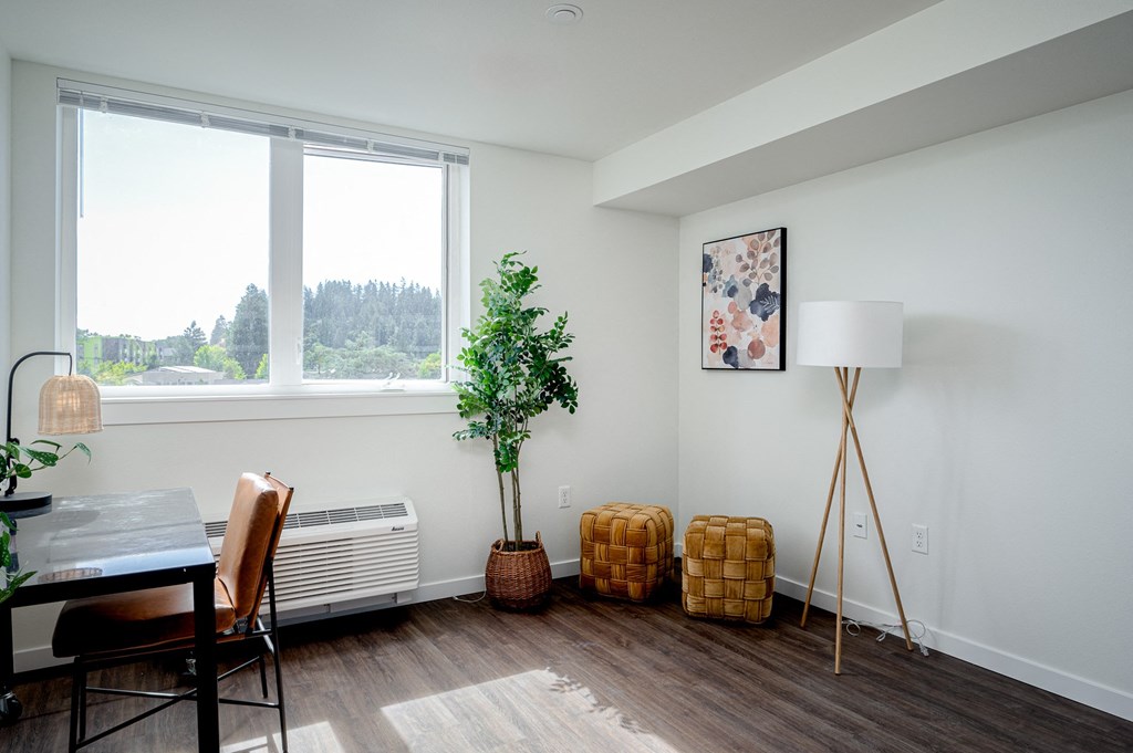 Room with large window, air conditioner, desk and chair