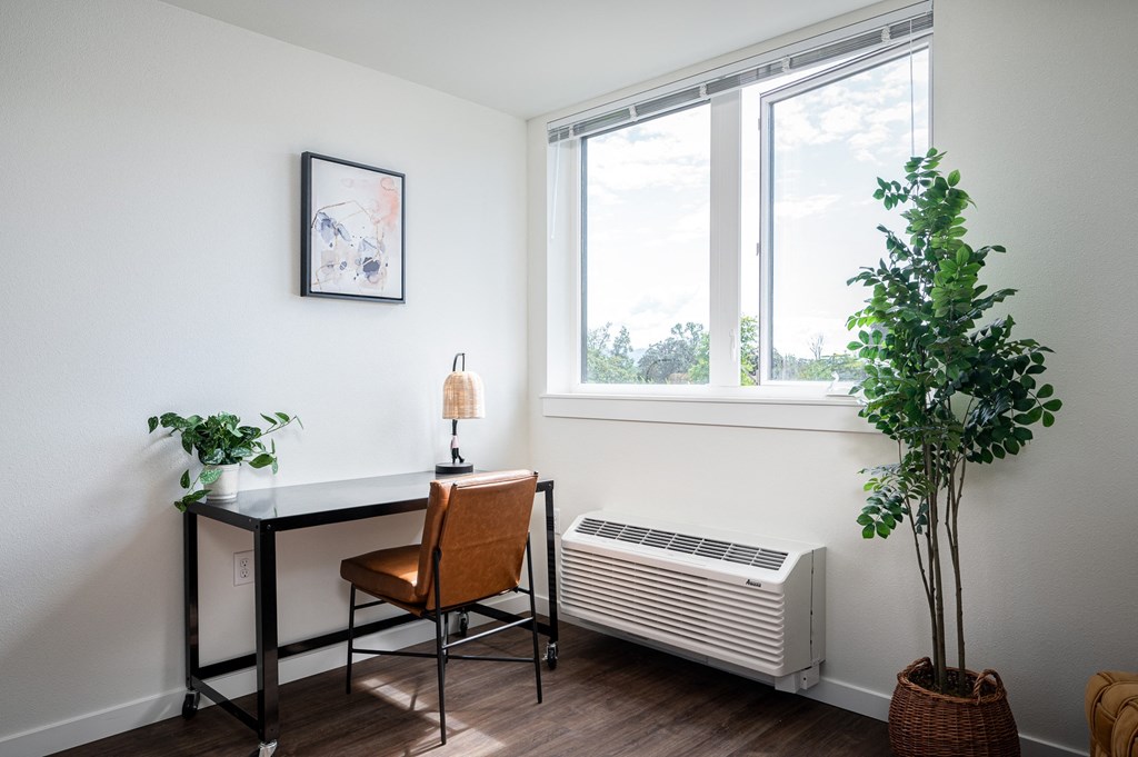 Room with large window, air conditioner, desk and chair