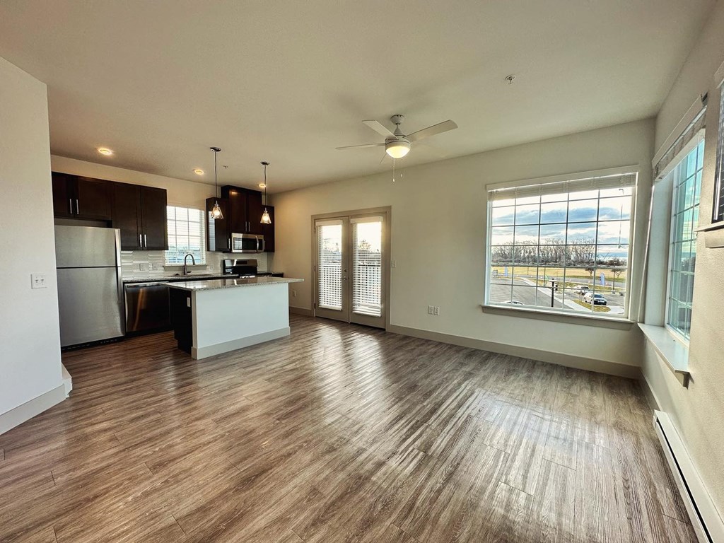 a living room with a kitchen and a ceiling fan