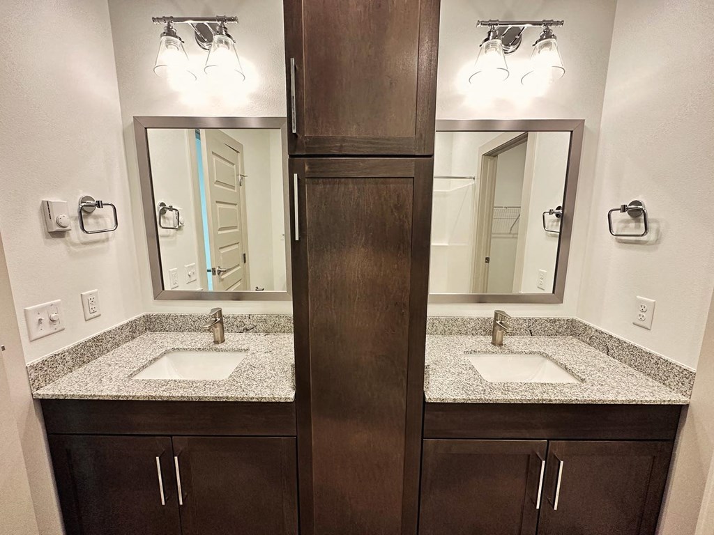 a bathroom with two sinks and two mirrors
