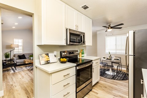 A modern kitchen with white cabinets and stainless steel appliances.