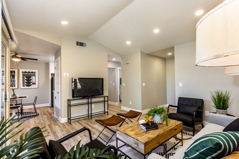 A living room with a wooden coffee table and a black couch.