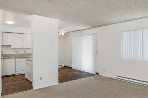the spacious living room and kitchen of an apartment