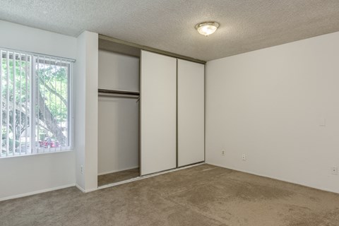 an empty living room with white walls and a window