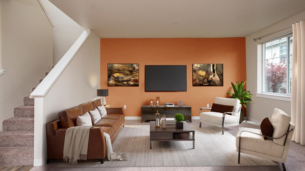 a living room with an orange accent wall and a brown couch