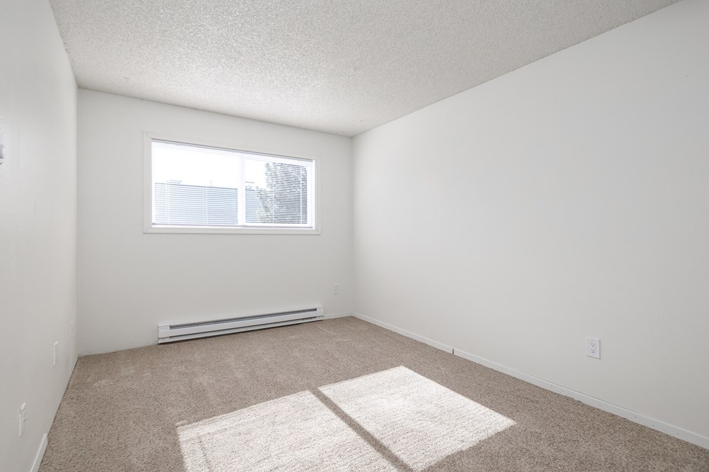 an empty room with white walls and a window
