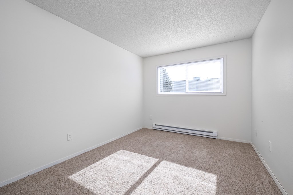 an empty room with white walls and a window