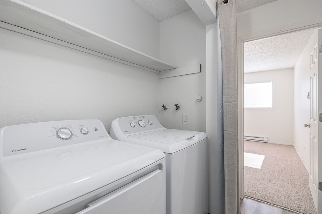 a washer and dryer in a laundry room with a door to a bathroom