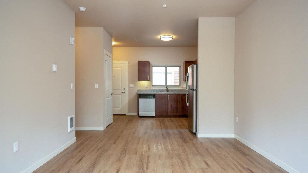 a large empty kitchen with a wooden floor