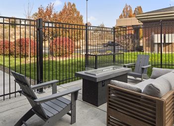 a patio with a table and chairs and a fire pit