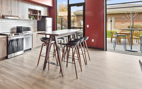 a kitchen with a table and chairs in front of a window