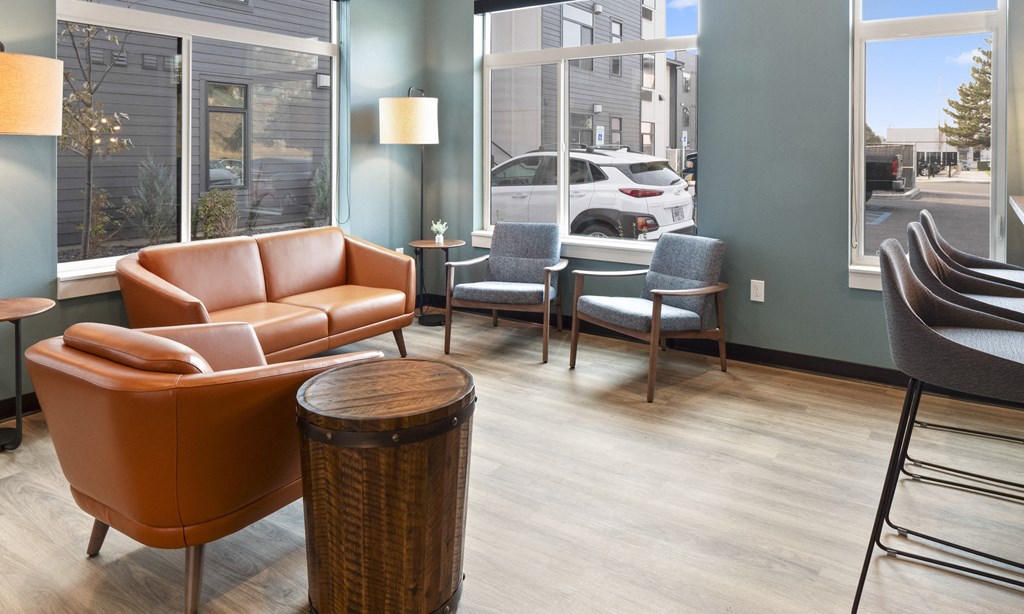 a living room with couches chairs and a table in front of a window