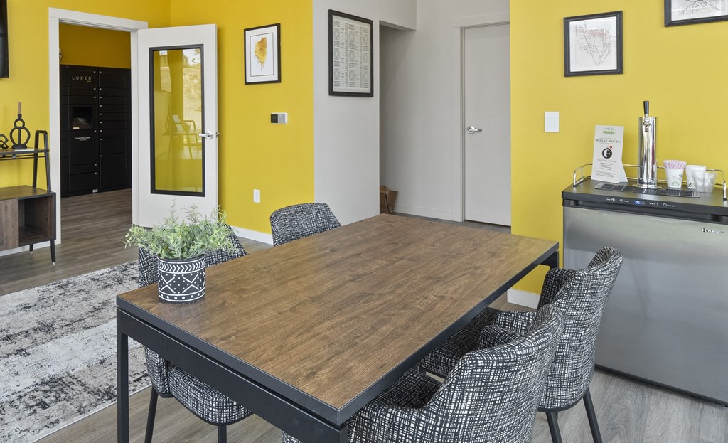 a dining room with yellow walls and a wooden table and chairs