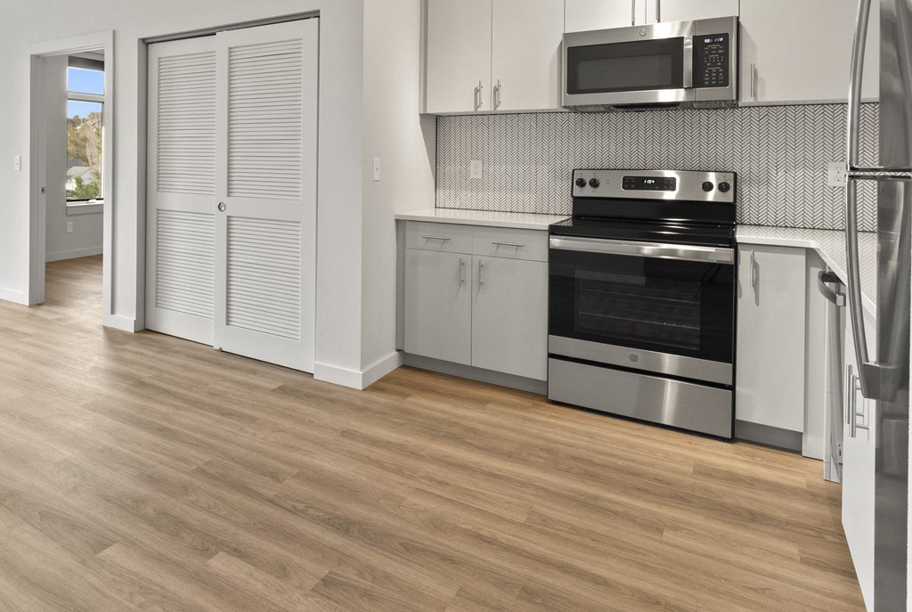 a kitchen with stainless steel appliances and white cabinets