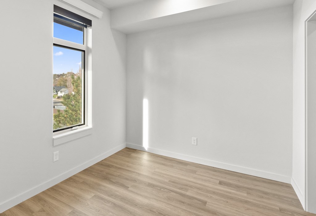 an empty room with white walls and a window