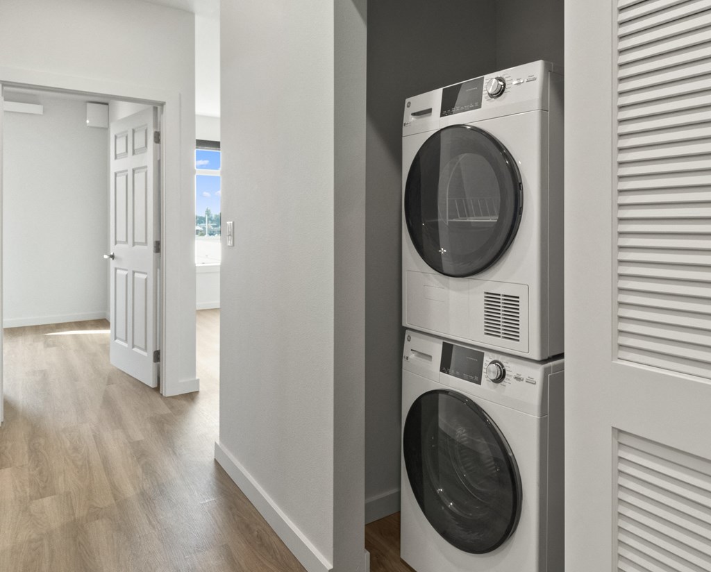 a washer and dryer in a living room with a door to a hallway