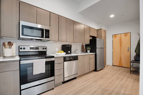 A modern kitchen with wooden cabinets and stainless steel appliances.
