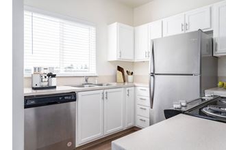 a kitchen with white cabinets and stainless steel appliances