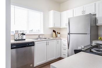 a kitchen with white cabinets and stainless steel appliances