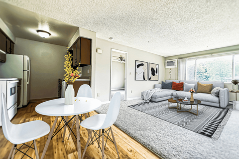 A modern living room with a dining table and chairs.