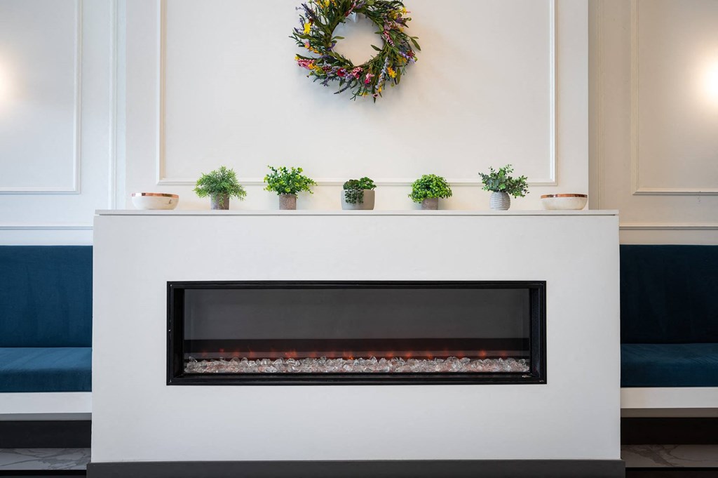 a living room with a fireplace and a mantel with potted plants on it