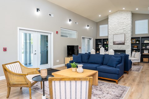 A living room with a blue couch and a wooden chair.