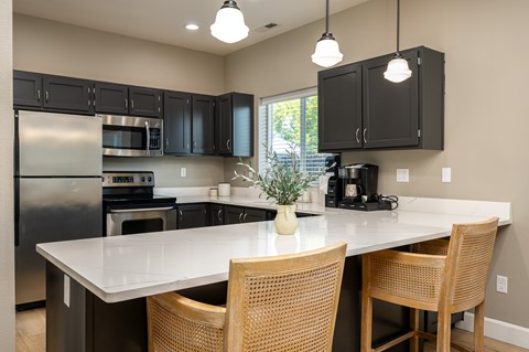 A kitchen with a table and chairs in front of it.